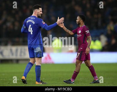 Cardiff City's Sean Morrison (sinistra) e Manchester City's Raheem Sterling agitare le mani dopo la Emirates FA Cup, quarto round corrispondono a Cardiff City Stadium. Foto Stock