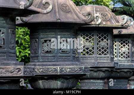 Lanterne di pietra nel Parco di Ueno, Taito Ward, Tokyo, Giappone. Linea di giapponese lanterne tradizionali o le torri faro a Ueno al Santuario di Toshogu. Foto Stock