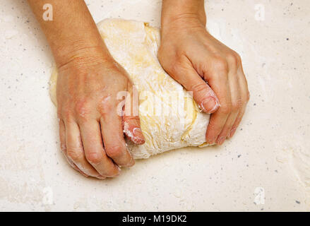 Le mani del cuoco che massaggia la pasta per pane Foto Stock