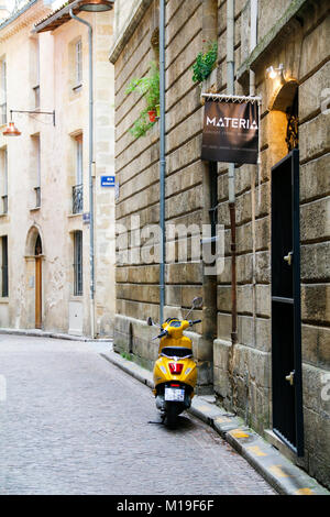 Giallo scooter parcheggiato su rue du Puits Descujols, Bordeaux, Gironde, Nouvelle-Aquitaine, Francia. Foto Stock