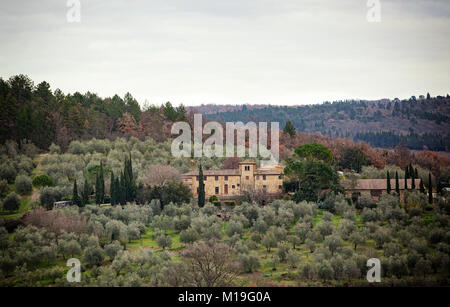 Il paesaggio toscano e strada di campagna con cipressi, alberi e palazzi antichi. Regione Toscana in Italia. Foto Stock