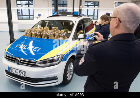Primi esempi di pelliccia orsetti di peluche sono presentati sulla cima di un'auto della polizia nel corso di un incontro con la stampa a Postdam, Germania, 29 gennaio 2018. Il Teddy Bear sarà distribuito a tutti i veicoli della polizia e aiutare gli ufficiali guadagnare la fiducia dei feriti, spaventato i bambini. Foto: Ralf Hirschberger/dpa Foto Stock