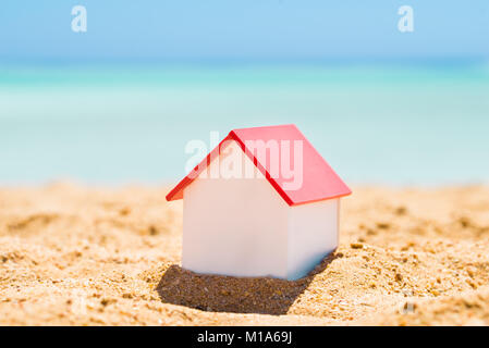 Casa singola modello sulla sabbia in spiaggia Foto Stock