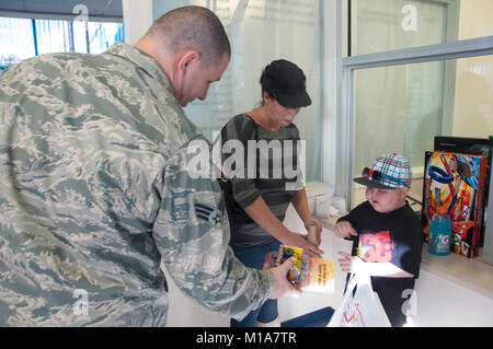 SrA Thomas Thornburg della 163d Ala di ricognizione, 163d Manutenzione aeromobili squadrone, offre giocattoli per i bambini che sono i pazienti all'Università di Loma Linda ospedale per bambini, Dic 14, 2012. Il aviatori dal California Air National Guard sono state sperando di poter visitare e illuminare la giornata dei bambini con doni come i bambini ricevono la cura al paziente in uscita centro in cui essi hanno spesso a visitare un paio di volte a settimana.(Air National Guard photo/Master Sgt. Julie Avey) Foto Stock