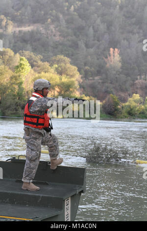 Sgt. 1. Classe Ben Nievera, sottufficiale nella carica di 132Multirole Bridge Company (MRBC), California Army National Guard, dirige il suo lancio e il team di recupero come essi attraversano la Cache Creek Fiume 7 Agosto a Cache Creek National Park in Yolo County, California. Nievera e la sua banda di 30 California guardie nazionali costruito un ponte galleggiante per aiutare CAL FIRE spostare i veicoli e le attrezzature per la lotta contro il fuoco rocciosa. (U.S. Esercito nazionale Guard foto/Staff Sgt. Eddie Siguenza.) Foto Stock