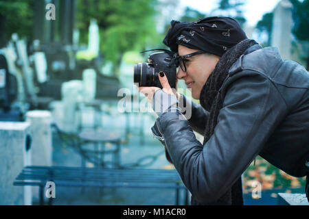 Ispanico fotografo femminile prendendo foto macro su un cimitero Foto Stock