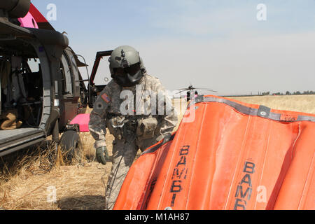 Il personale Sgt. Ge Xiong, capo equipaggio a bordo di una UH-60 Black Hawk dal teatro 1106th Aviation supporto gruppo di Manutenzione (TASMG), California Army National Guard, ispeziona un 2,600-gallone Bambi Bucket prima di un mese di luglio 13 Garza Fire missione al Coalinga Municipal Airport, Fresno County, California. (Esercito Guardia Nazionale foto/Staff Sgt. Eddie Siguenza.) Foto Stock