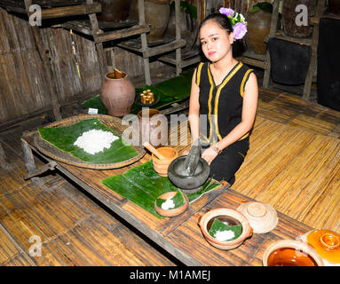 Piuttosto giovane donna con fiori nei capelli a Mari Mari Villaggio Culturale, Kota Kinabalu, Sabah Borneo, Malaysia Foto Stock