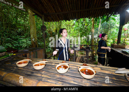 Una giovane donna guida che mostra tradizionali ingredienti alimentari a Mari Mari Villaggio Culturale, Kota Kinabalu, Sabah Borneo, Malaysia Foto Stock