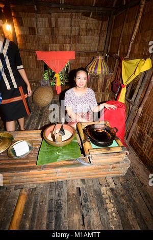 Piuttosto giovane donna malese cucinare frittelle a Mari Mari Villaggio Culturale, Kota Kinabalu, Sabah Borneo, Malaysia Foto Stock