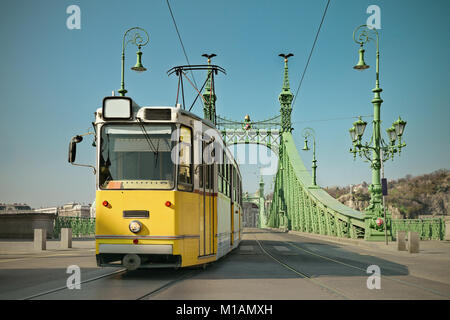 Tram storico sul ponte della Libertà a Budapest, Ungheria, su un luminoso giorno, tonica immagine Foto Stock