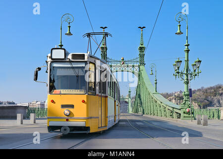 Tram storico sul ponte della Libertà a Budapest, Ungheria, su un luminoso giorno Foto Stock