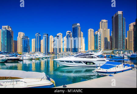 Dubai sunny cityscape. Cielo blu chiaro su grattacieli. Yacht di lusso in marina nel centro cittadino di Dubai. Foto Stock