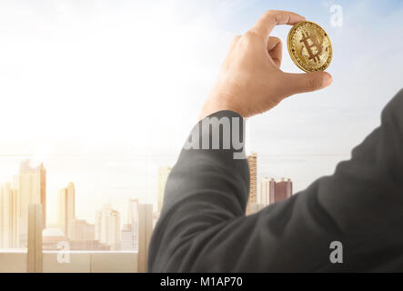 Imprenditore bitcoin tenendo a portata di mano con il paesaggio sullo sfondo Foto Stock