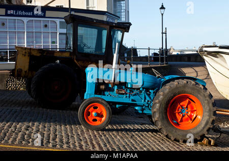 Trattori sulla rampa in Cromer pronto per il traino di barche in mare in Norfolk England Regno Unito Foto Stock