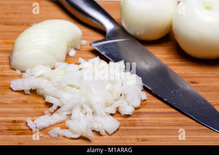 Cipolla e fette di cipolla sul tagliere di legno. Foto Stock