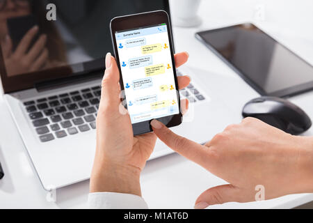 Close-up di una mano azienda Smart Phone con nuovi messaggi sullo schermo Foto Stock