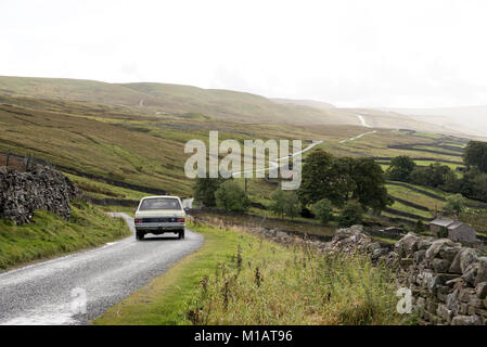 Vecchia auto su una strada remota in Swaledale, Yorkshire Dales, Inghilterra. Foto Stock