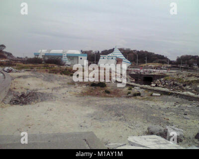 2 marzo 2012, Soma, Fukushima, Giappone. Quasi 1 anno dopo il Tohoku Earthquake-Tsunami disastro in Giappone. Il bagno pubblico in spiaggia Matsukawaura sinistra danneggiata dopo lo Tsunami come pure arrugginita Swing. Il quartiere residenziale di La spiaggia era danneggiato tuttavia adesso nel 2018 il frangiflutti è stato costruito lì. Foto Stock