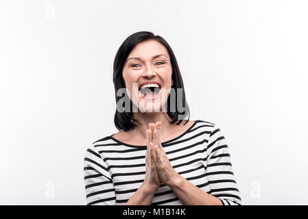 Overjoyed donna battendo le mani e grinning Foto Stock