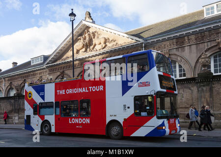 Un autobus turistico dipinto nei colori della bandiera Union Jack passa davanti ai Royal Mews a Buckingham Palace a Londra, Regno Unito. Foto Stock