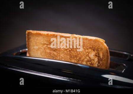 Moderno tostapane bianco e fette di pane tostate si tostano all'interno su  un tavolo di legno in cucina Foto stock - Alamy