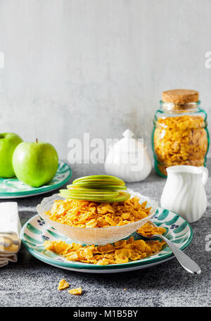 Cornflake cereali in una ciotola con il latte e una mela verde , colazione veloce Foto Stock