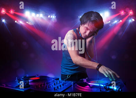 Bello adolescente dj record di miscelazione di fronte ad una folla sul palco Foto Stock