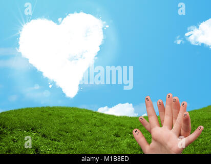 Felice allegro smiley dita guardando a forma di cuore ad cloud Foto Stock