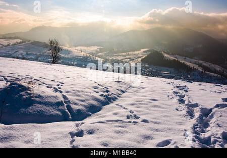 Pendio nevoso in campagna montuosa. splendida meteo con nubi sul crinale del monte. Foto Stock