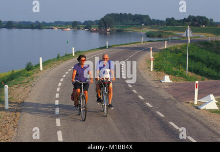 I Paesi Bassi. Woudrichem. Uomo Donna e cane escursioni in bicicletta. Foto Stock