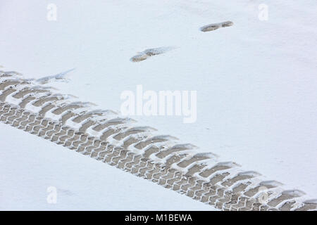 Tracce del trattore sulla coperta di neve su strada. Vista da sopra. Foto Stock