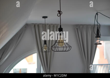 Filo industriale lampadari in loft soggiorno Foto Stock