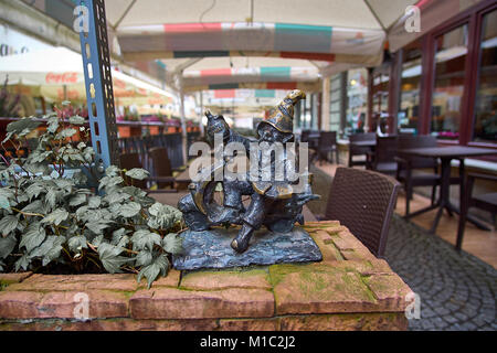Attrazione turistica di statue di Wroclaw di nani. Il vecchio gnome bere ale. Foto Stock