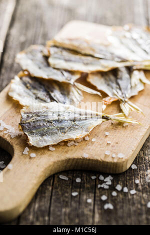 Asciugato il pesce salato sul vecchio tavolo in legno. Foto Stock