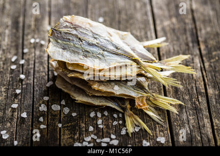 Asciugato il pesce salato sul vecchio tavolo in legno. Foto Stock