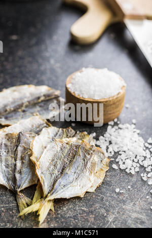 Asciugato il pesce salato sul vecchio tavolo da cucina. Foto Stock