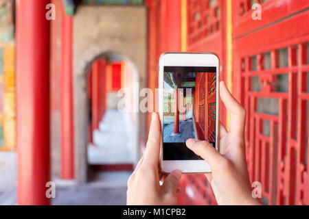 Turistica prendendo foto nella città proibita con uno smartphone Foto Stock