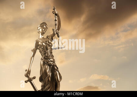 Statua della giustizia contro NUVOLOSO TRAMONTO. Foto Stock