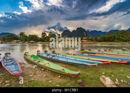 Long Tail barche sul tramonto al brano river, Vang Vieng, Laos. Foto Stock