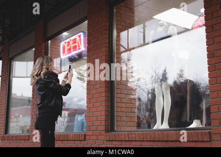 La donna sta immagine di condire con il telefono cellulare Foto Stock