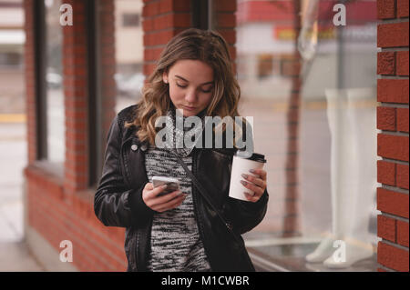 Bella ragazza utilizzando mobile mentre un caffè Foto Stock