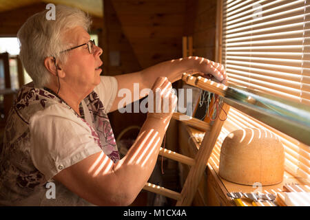 Senior donna seta tessitura al shop Foto Stock