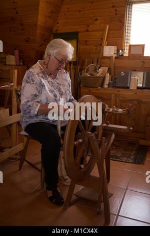 Senior donna seta tessitura al shop Foto Stock