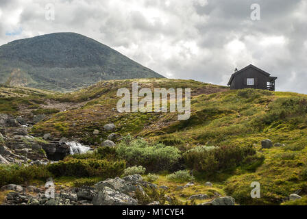 Una cascata e una piccola casa in montagna, Norvegia Foto Stock