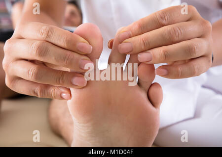 Close-up di un terapeuta di mano il trattamento di persona il piede in clinica Foto Stock