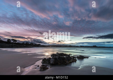 Un tramonto spettacolare sulla spiaggia di Arnao, Asturias, fotografando i diversi colori, forme e texture delle nuvole, riflessa nella sabbia fine Foto Stock