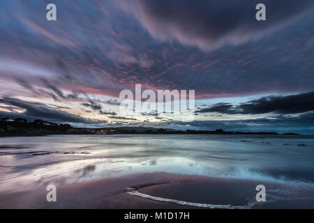 Un tramonto spettacolare sulla spiaggia di Arnao, Asturias, fotografando i diversi colori, forme e texture delle nuvole, riflessa nella sabbia fine Foto Stock