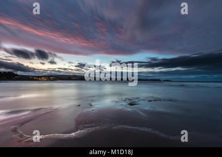 Un tramonto spettacolare sulla spiaggia di Arnao, Asturias, fotografando i diversi colori, forme e texture delle nuvole, riflessa nella sabbia fine Foto Stock