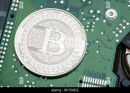 D'argento metallizzato bitcoins sul circuito elettronico della scheda madre.crypto valuta mining.denaro digitale sulla rete blockchain Foto Stock